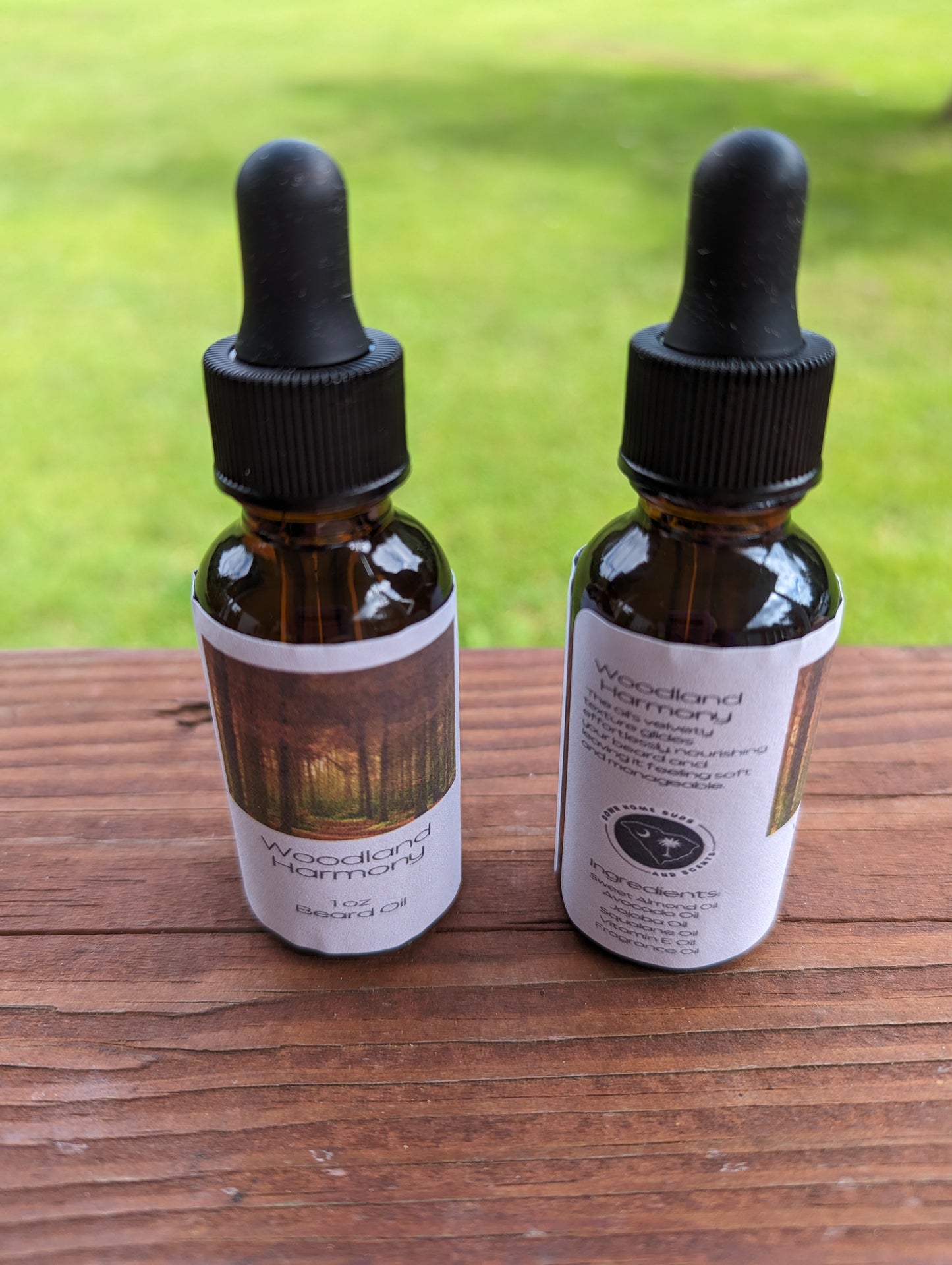 Pictured is two 1 oz amber colored dropper bottles. Labeled with Woodland Harmony Beard Oil 1 oz